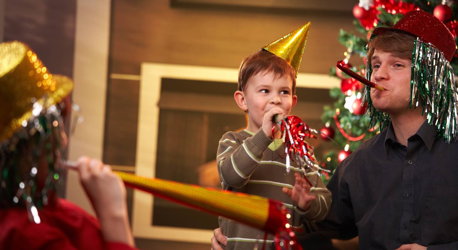 Family celebrating New Year's with party hats